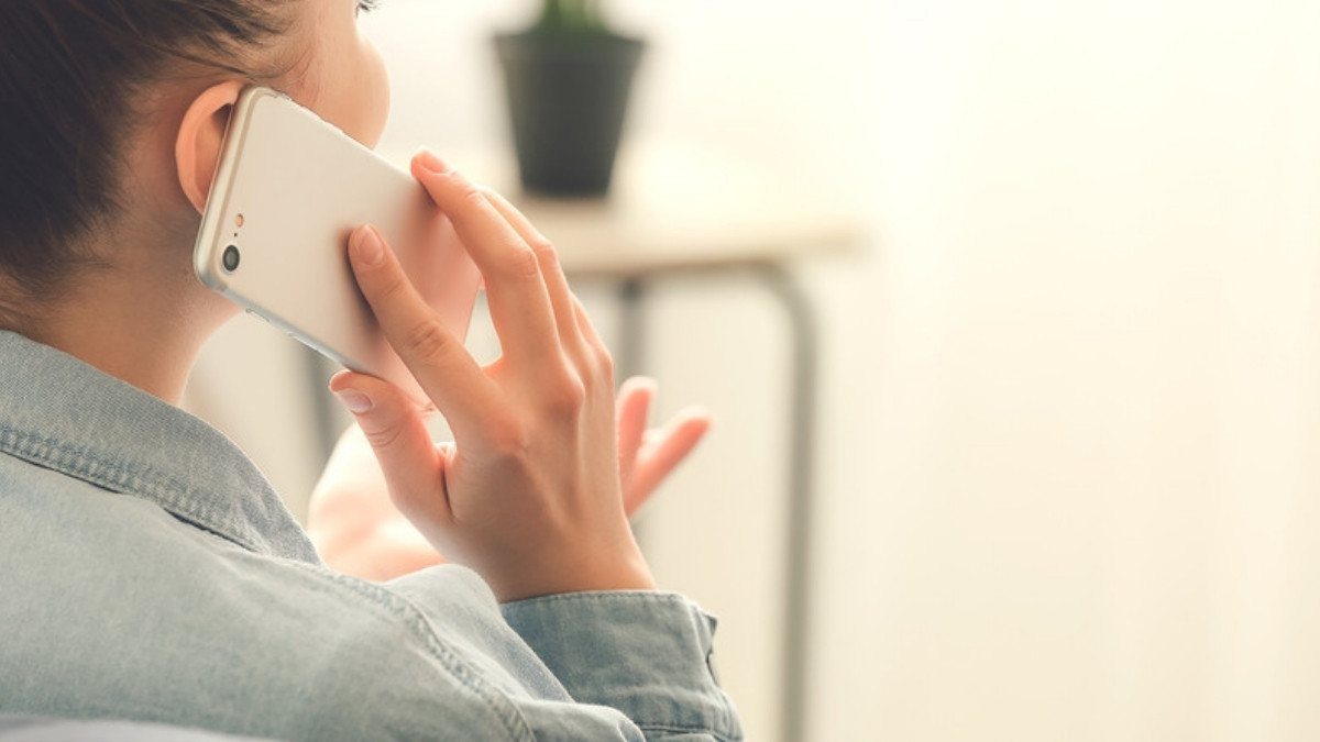 A woman holds a phone to her ear at home, an easy way to start a talk with apartment injury lawyers in Summerville about a lease