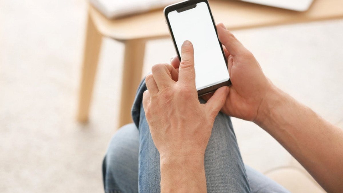 Hands hold a smartphone at home while someone looks up delivery truck accident lawyers in Summerville after a crash