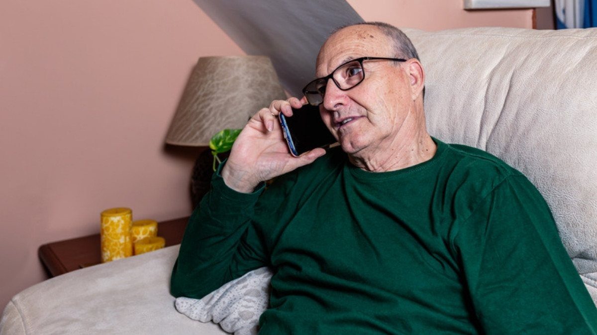 An older man in glasses talks on his phone from the couch, a call where fatal truck accident lawyers in Summerville start with records