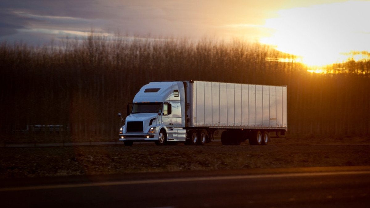 A white tractor trailer rolls along a highway at sunset, a rig fatal truck accident lawyers in Summerville trace to its carrier