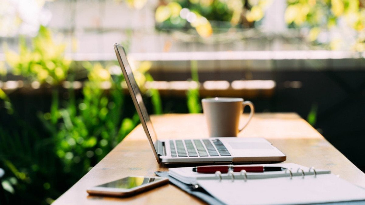 A laptop, a phone and an open notebook wait on a sunny table, ready for notes on comparative negligence and a shared fault claim