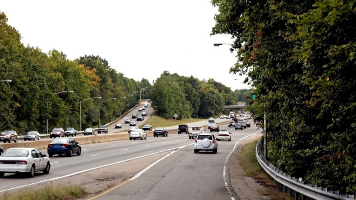 Traffic flows along a divided highway lined with trees, the kind of commuter route Ladson car accident lawyers ask about