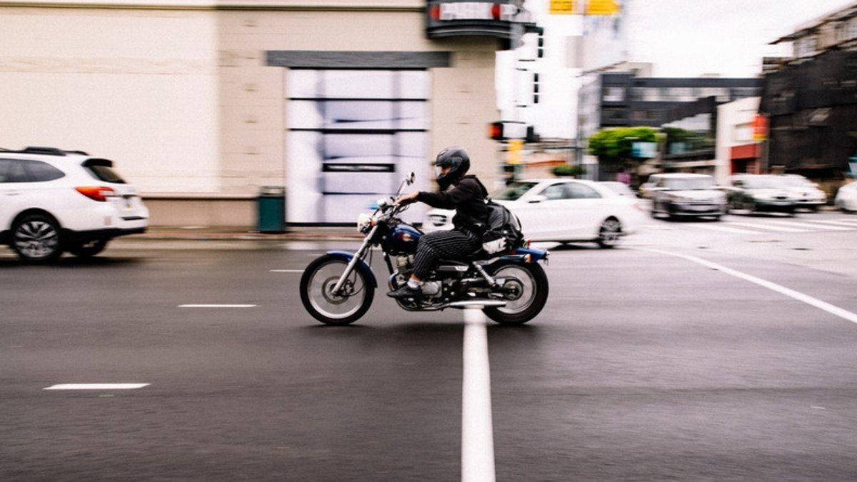 A cruiser rider crosses an intersection as cars wait nearby, the moment left turn motorcycle accident lawyers in Summerville study