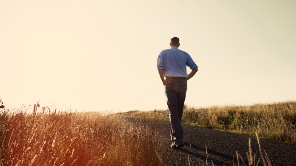 With no sidewalk in sight, a man walks the road edge at sunset, a setting pedestrian accident attorneys in Summerville often review