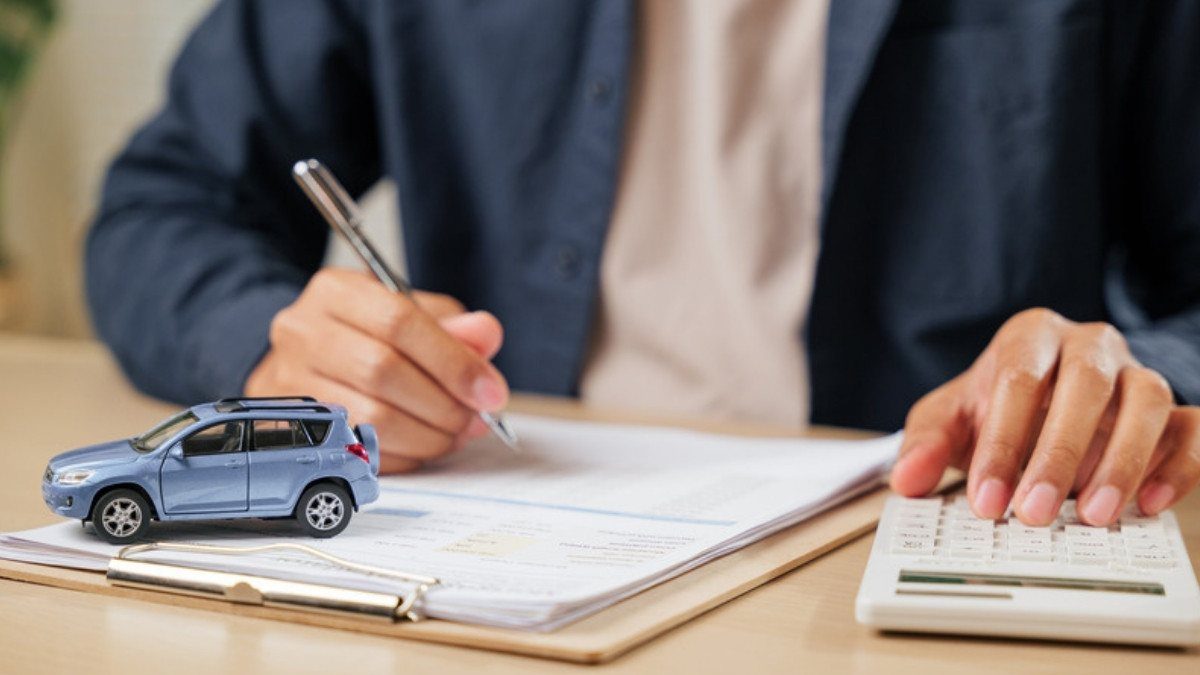 Hands sign an auto policy beside a toy car and calculator, the coverage pedestrian accident attorneys in Summerville check first