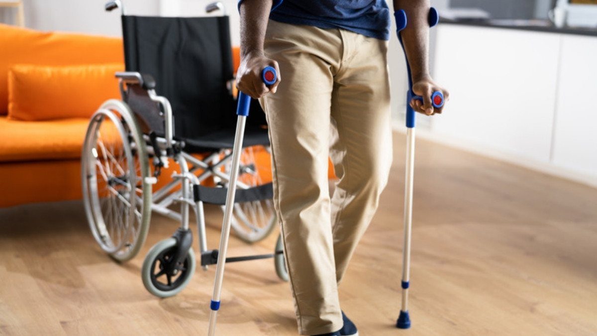A person on crutches walks past an empty wheelchair at home, the kind of recovery personal injury attorneys in Beaufort County document