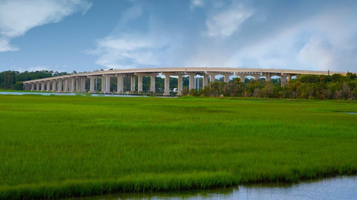 A long highway bridge crosses green salt marsh and a tidal creek on the way to Hilton Head Island