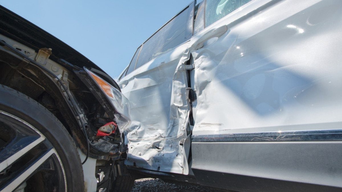 A dark car sits pushed into the crumpled door of a silver sedan, a side impact personal injury attorneys in Beaufort County examine