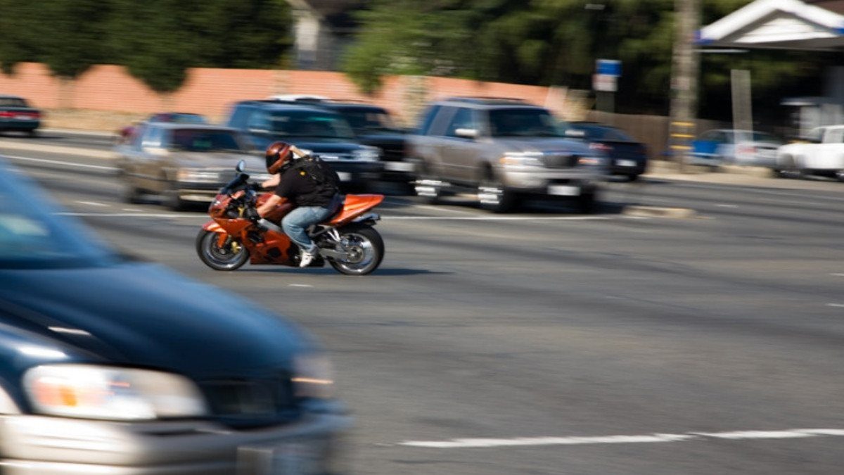 An orange motorcycle rides among cars and pickups, the traffic mix personal injury attorneys in Charleston County see in many claims
