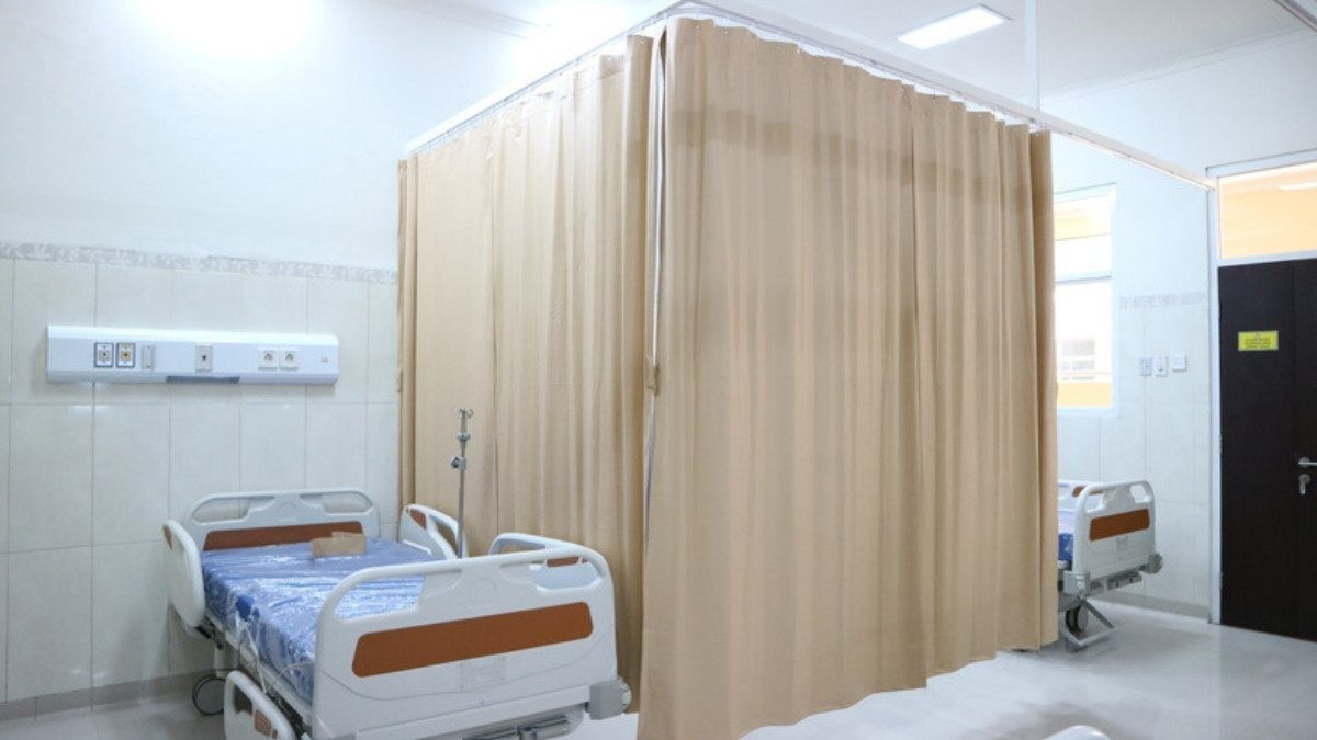 Empty hospital beds sit beside a tan privacy curtain, a reminder that personal injury attorneys in Colleton County gather every chart
