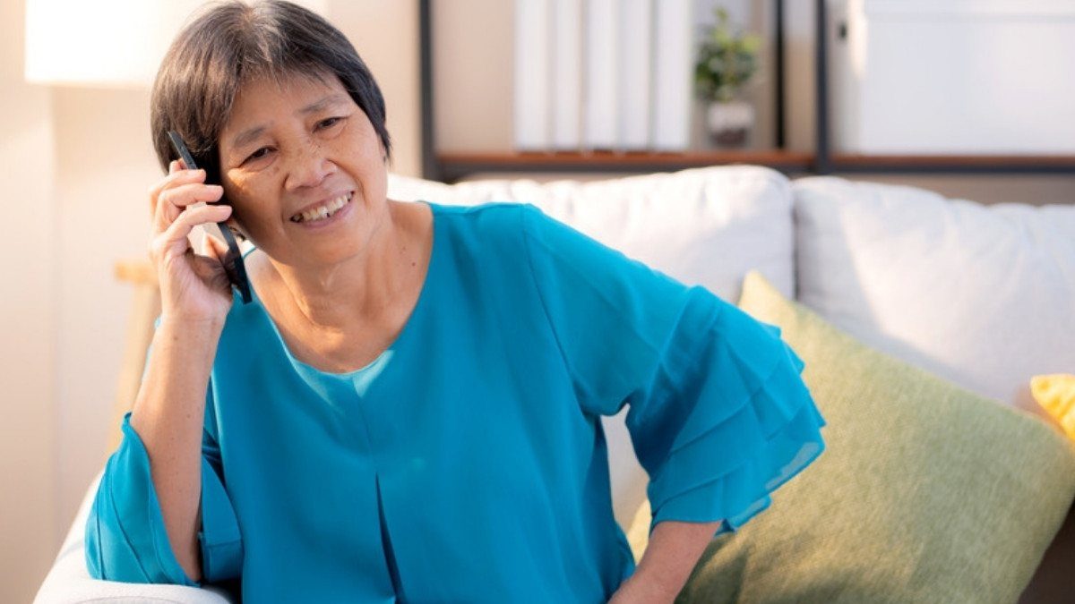 A woman talks on her phone from a comfortable sofa at home, a simple way to reach personal injury attorneys in Colleton County