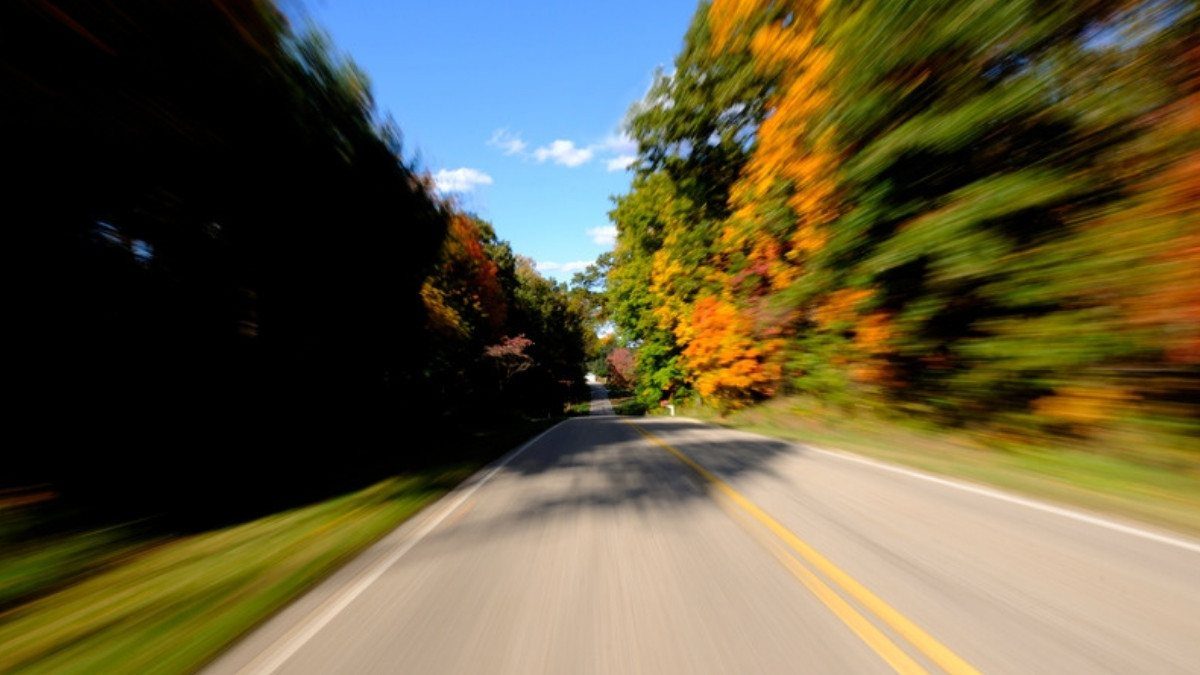 Trees blur past a road with a double yellow line, the kind of speed personal injury attorneys in Dorchester County see in crash reports