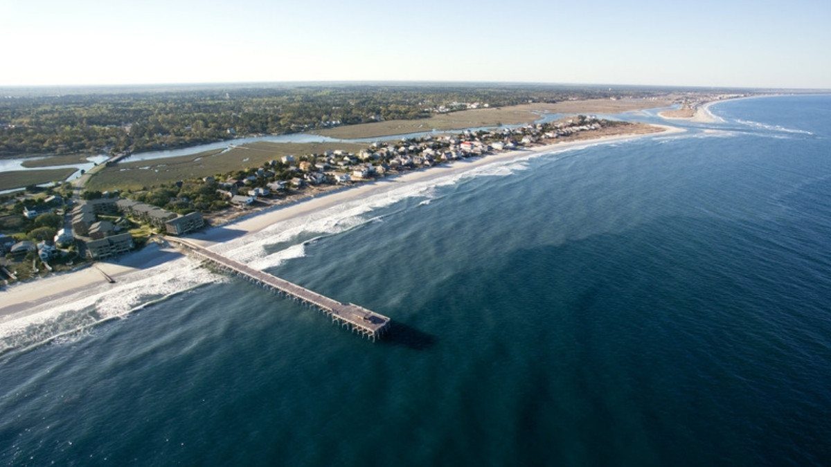 Seen from above, Pawleys Island beach homes, a fishing pier and marsh sit where personal injury attorneys in Georgetown County work