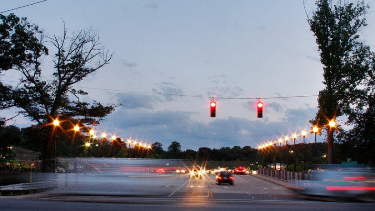 Traffic signals hang over a busy road at dusk, the kind of junction personal injury attorneys in Georgetown County study on US 17