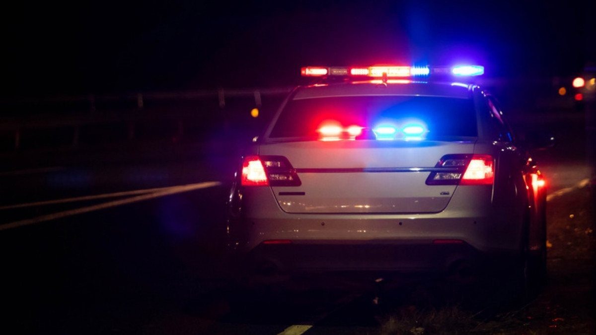 A patrol car flashes red and blue lights on a dark roadside, a late night scene personal injury attorneys in Orangeburg County know