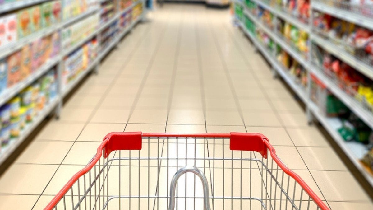 A shopping cart heads down a grocery aisle with a tile floor that retail slip and fall lawyers in Summerville examine after a fall