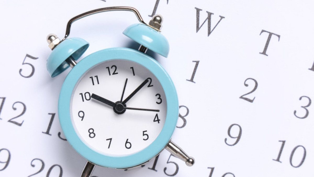 A small blue alarm clock rests on a calendar page, a reminder that the statute of limitations keeps running after a crash