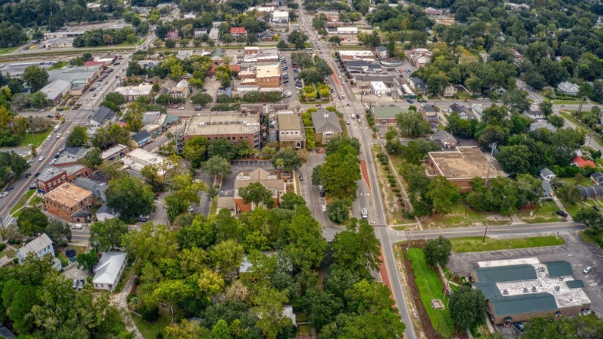 An aerial view shows tree lined streets, rooftops and a main road running through Summerville, South Carolina