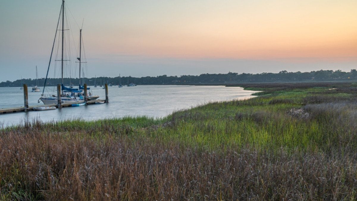 Sailboats rest past the marsh grass at sunset on the Beaufort waterfront, where South Carolina personal injury attorneys take claims