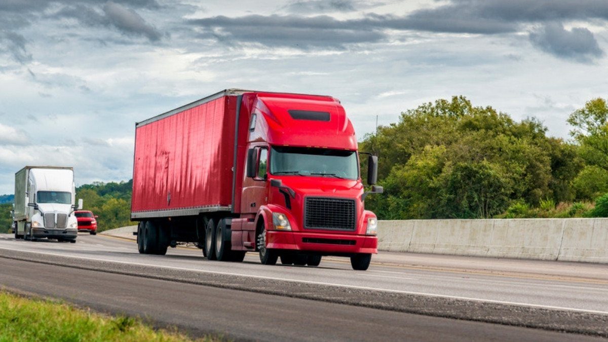 Tractor trailer accident lawyers in Summerville inspect whole rigs like this red truck and trailer moving along an interstate