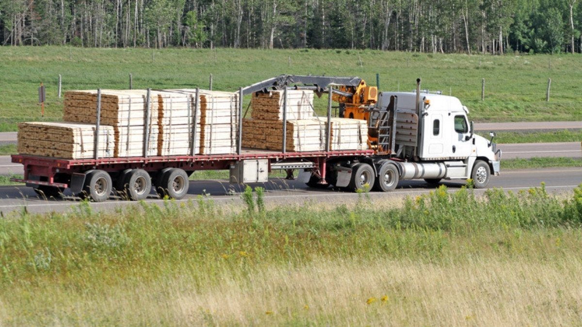 Truck accident attorneys in Summerville start with loads like this flatbed of stacked lumber moving along a rural highway