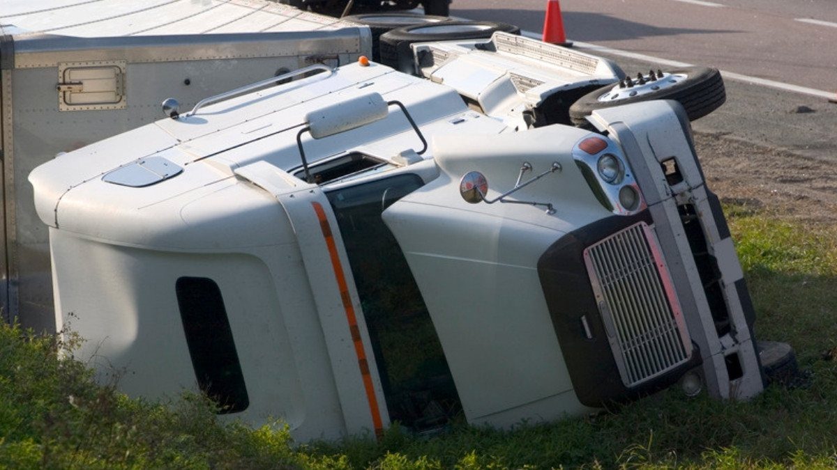 An overturned semi cab rests in the grass beside the highway, a scene truck accident attorneys in Summerville study after a wreck