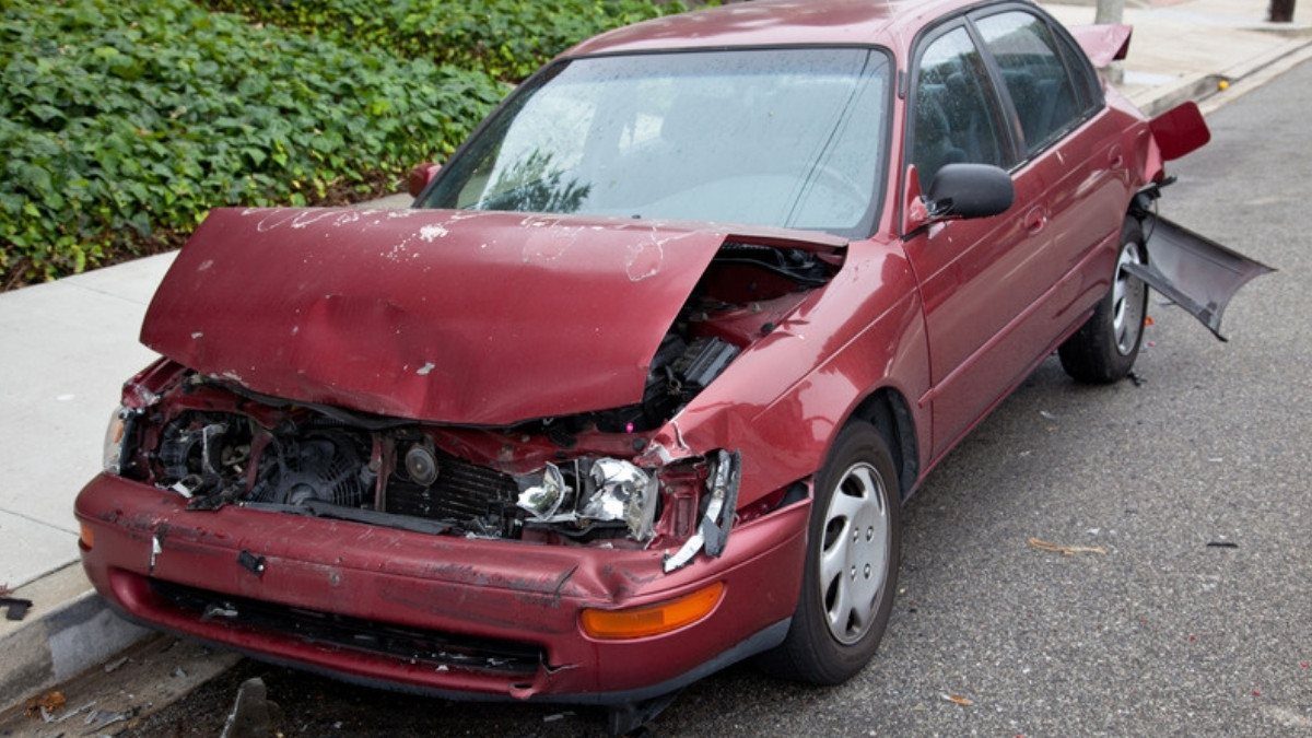A red sedan with a crushed hood sits at the curb, the kind of damage truck accident attorneys in Summerville weigh when fault is shared