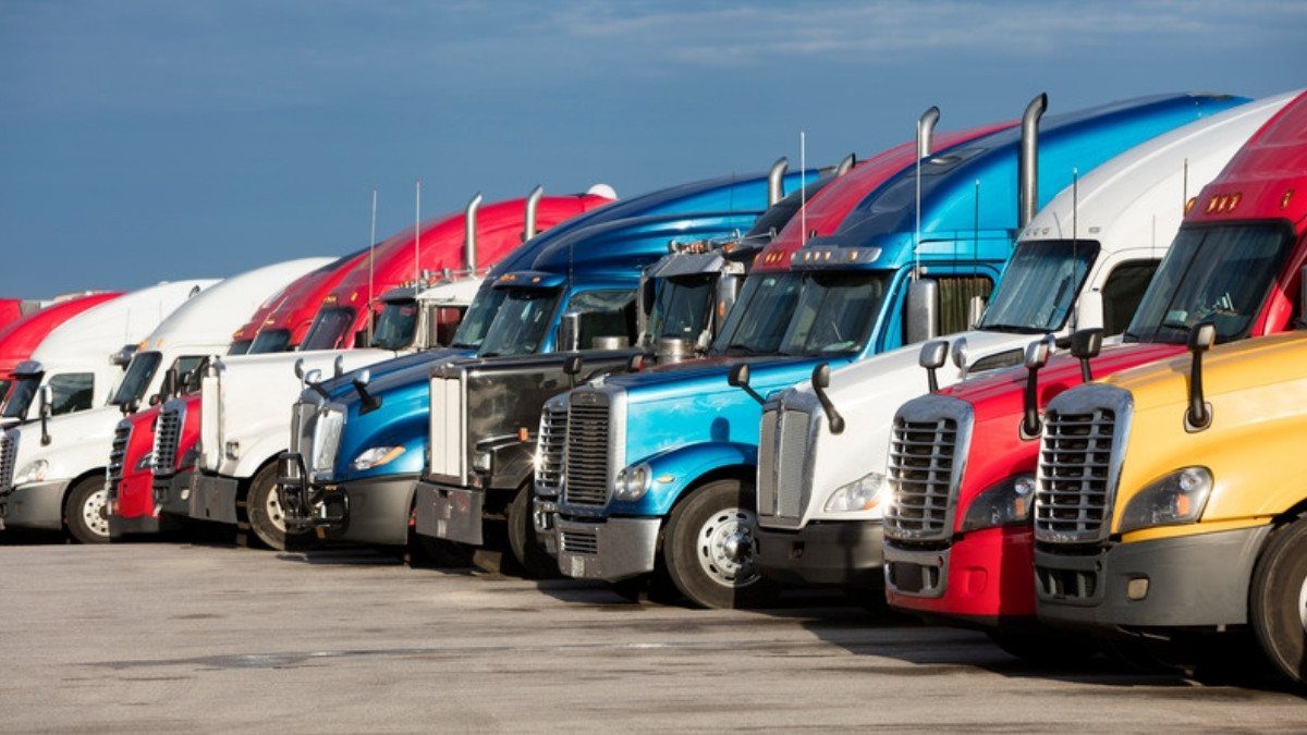 A long row of parked semi tractors reminds truck accident attorneys in Summerville that every rig traces back to a company