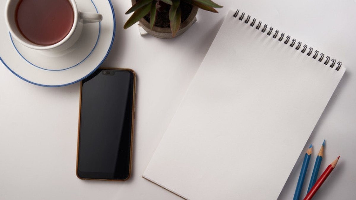 Tea, a phone and a blank notepad wait on a white table, ready for notes before calling truck accident lawyers in Berkeley County