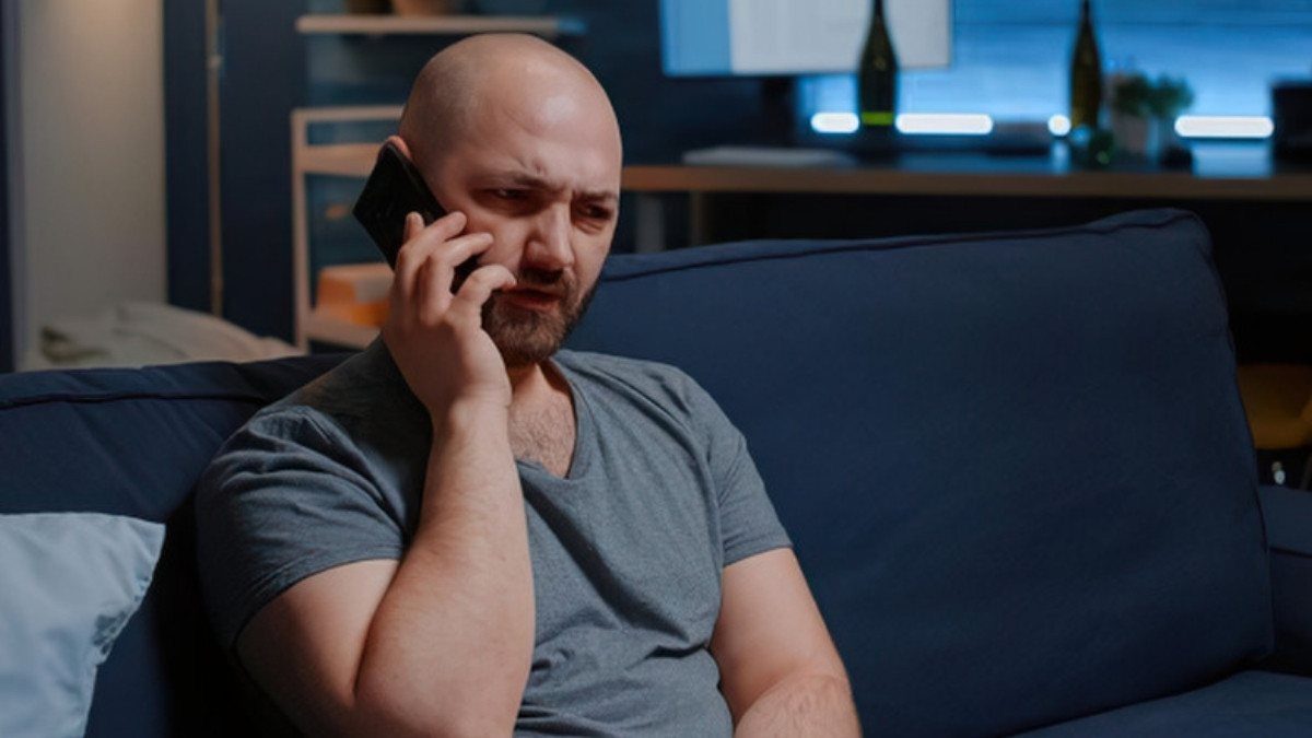 Resting on a couch at home, a man talks on the phone, one easy way to reach Uber accident lawyers in Summerville while recovering