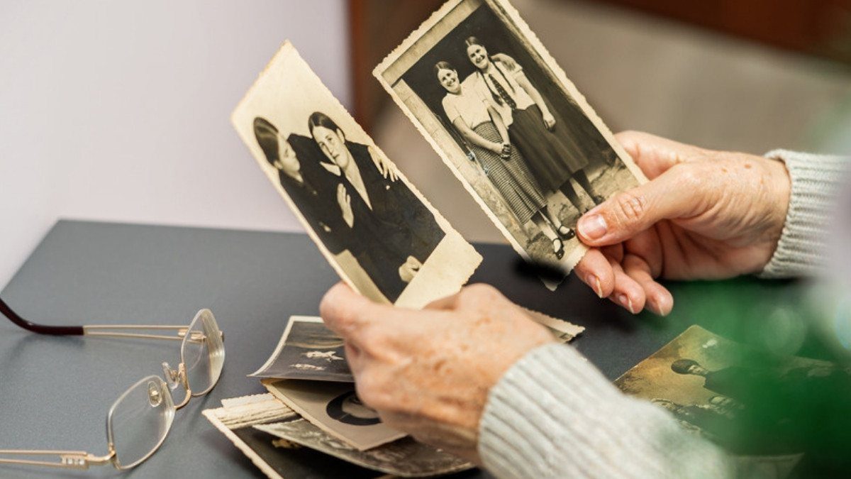 An older woman holds faded family photos by her reading glasses, a life story wrongful death attorneys in Summerville piece together